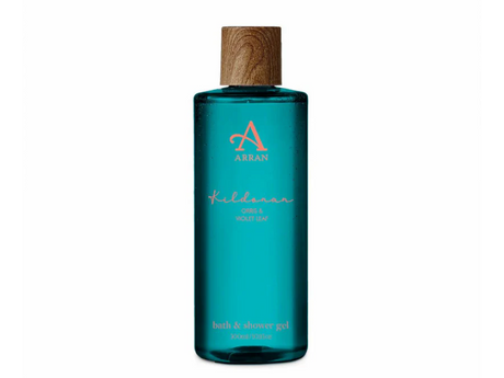 Blue bottle of ARRAN bath and shower gel with a wooden cap. The label reads "ARRAN, Kildonan, Orris & Violet Leaf, bath & shower gel, 300ml.