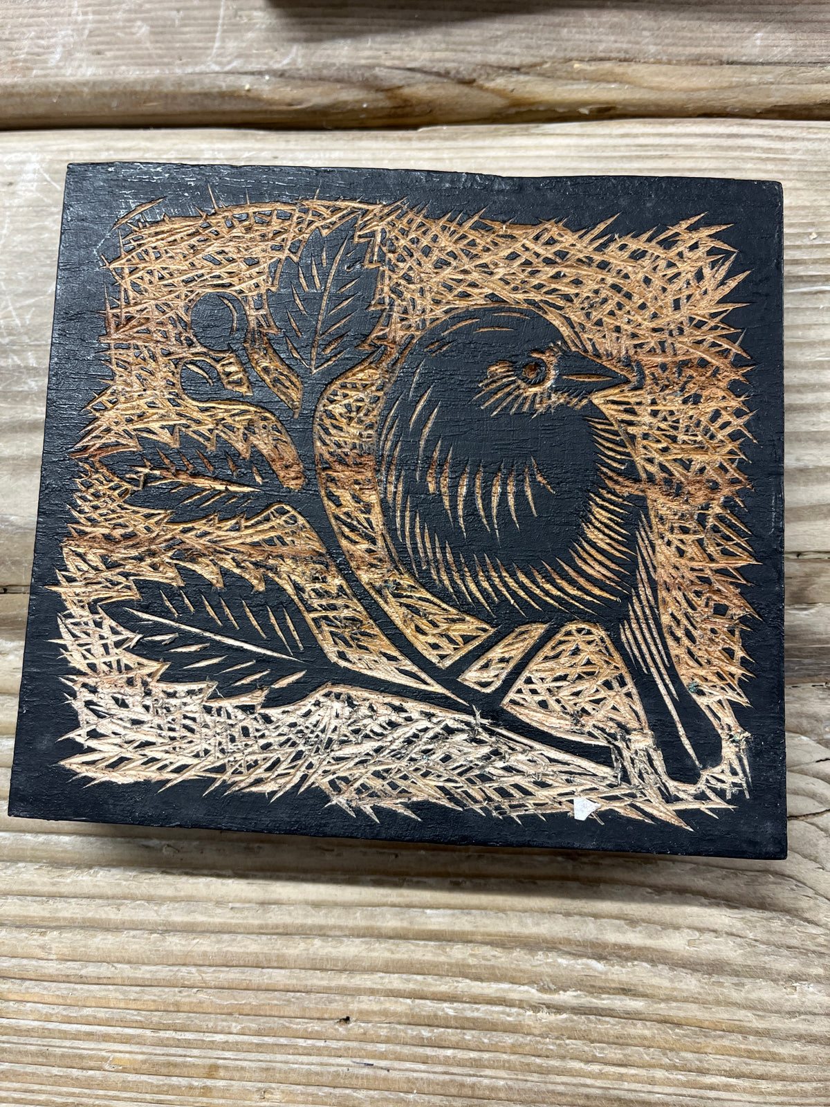 East of India Decorative Wooden Block featuring a natural wood finish and a burnt-wood relief carving of a bird perched on a leafy branch.