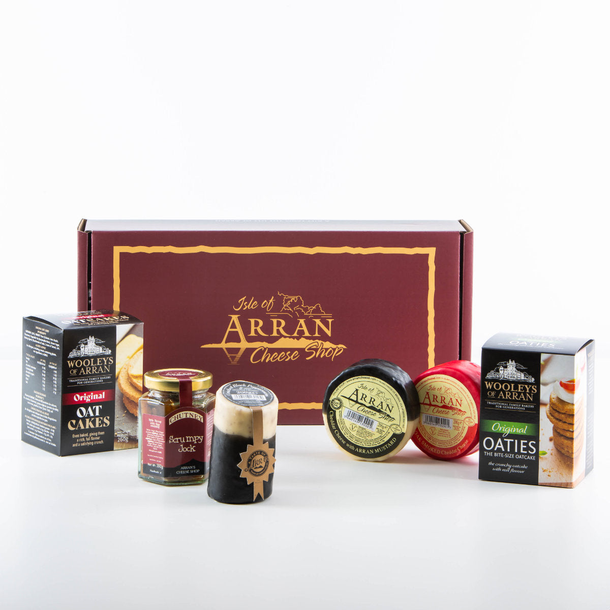 The Simply Arran Hamper features Isle of Arran cheese products, including Oak Smoked Cheddar rounds and oatcakes, accompanied by chutney, all tastefully arranged in a branded maroon gift box.