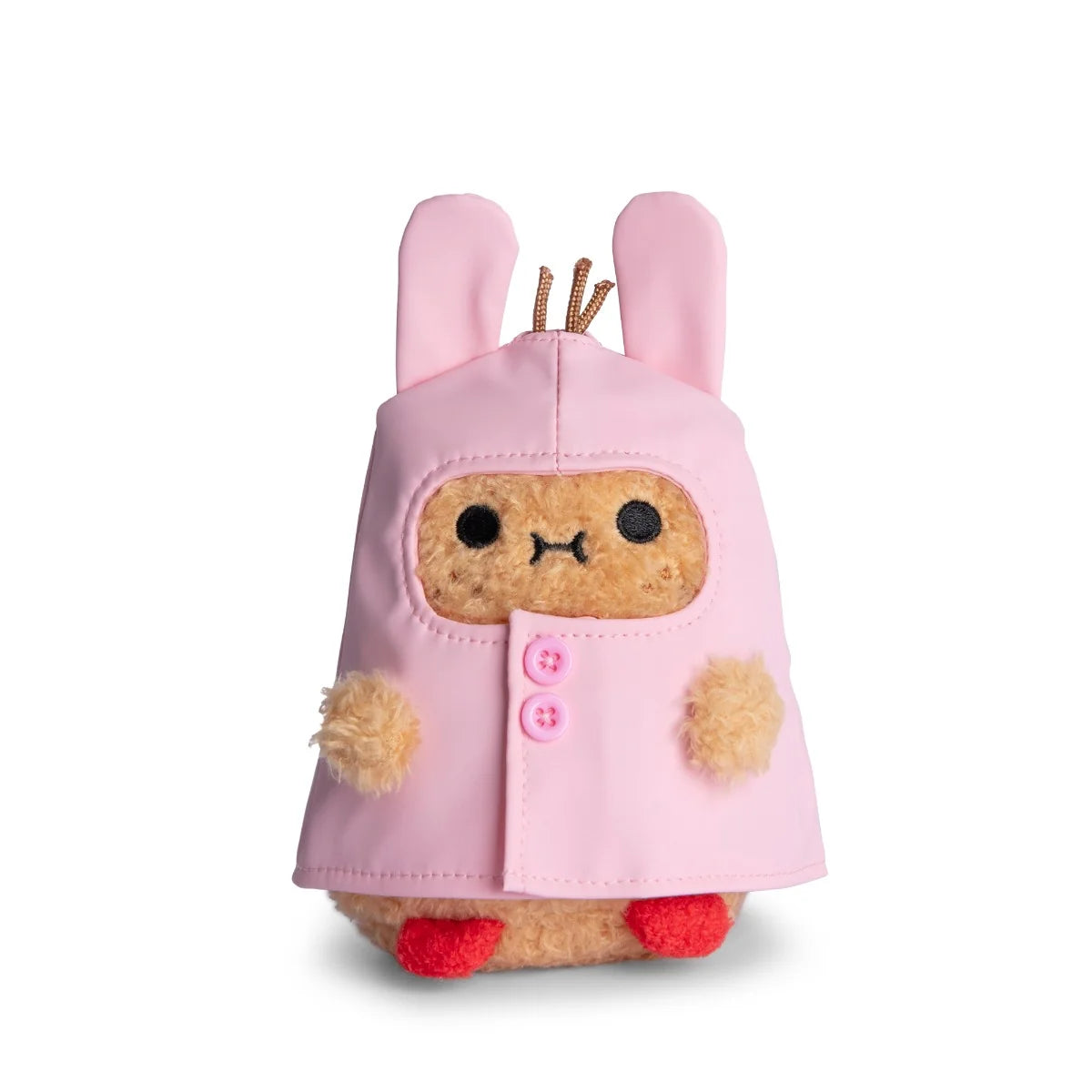 A cute Noodoll Ricespud Bunny Boot Pink Raincoat plush toy, shaped like a small animal, wears a pink hooded raincoat with bunny ears and pink buttons. It features small red feet and fuzzy beige paws, making it perfect for cuddling or display against a white background.