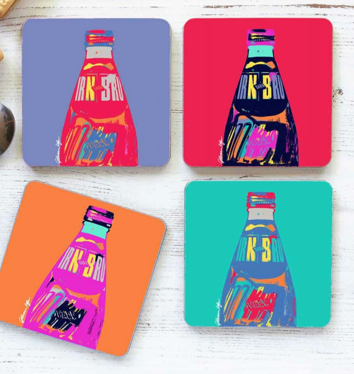 The IRN-BRU POP Art Set of 4 Coasters features bold pop art designs of Irn-Bru bottles on purple, red, orange, and teal backgrounds—bringing a vibrant touch of Scottish flair to any table.