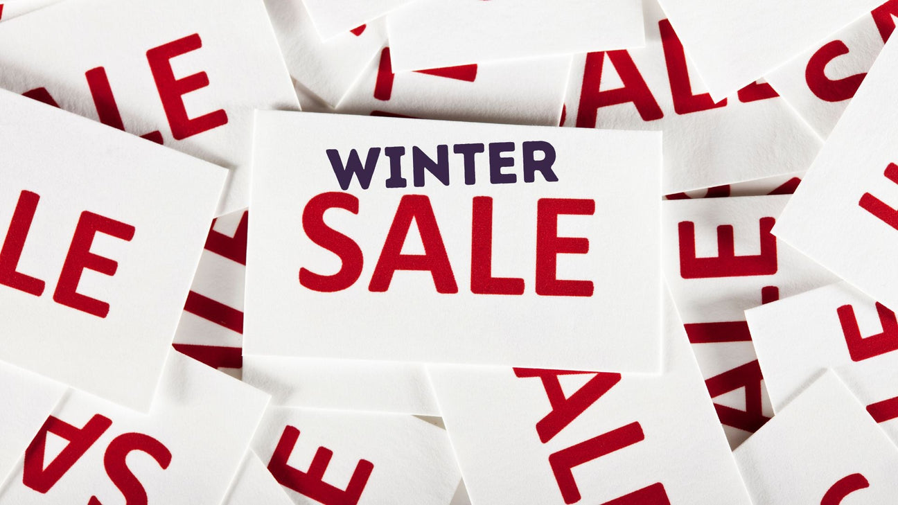 A card with the words "WINTER SALE" is placed on top of overlapping cards, each printed with the word "SALE" in bold red letters.