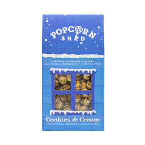 A blue box of Cookies & Cream Gourmet Popcorn Snack Box, featuring a window that reveals the cookies and cream popcorn inside. The packaging emphasizes all natural ingredients and showcases the irresistible flavor of crunchy cookie crumb pieces paired with smooth white chocolate popcorn for a delicious treat.