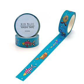 Ocean Washi Tape features vibrant blue tape with colorful fish, turtles, and bubbles. One roll stands upright while another is partly unrolled to display the charming ocean design—ideal for adding a splash of color to gift wrapping.