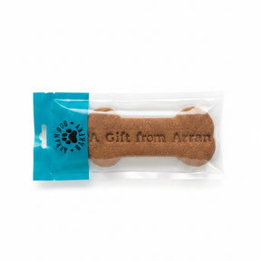 The Handmade Arran Dog Bone Biscuit is a large, natural dog treat shaped like a bone in clear packaging with a blue "Arran Dog Bakery" label. "A Gift from Arran" is printed on the biscuit.