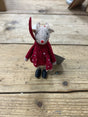 A small “Mouse with Polka Dot dress” stuffed toy, dressed in a red coat adorned with white polka dots and black shoes, stands on a wooden surface.
