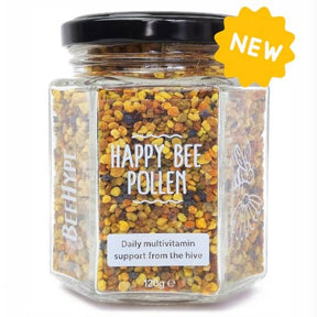 A hexagonal glass jar labeled "BeeHype Happy Bee Pollen" contains raw wildflower pollen granules. The label reads "Daily multivitamin support from the hive," with a yellow "NEW" badge highlighting this natural superfood.