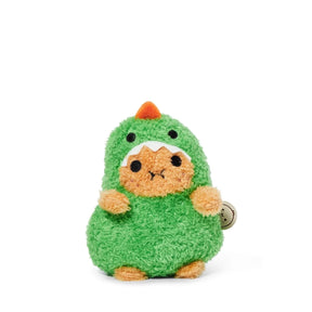 A small, plush toy with a round, orange face and paws, dressed in a fluffy green dinosaur costume featuring a tiny orange spike and white teeth on the hood, sits on a white background. The adorable Noodoll Ricespud Dinosaur is perfect for cuddling.