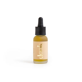 A small glass dropper bottle with yellow liquid, a black rubber top, and a beige label reading “dook” in gold letters stands upright on a white background—perfect for those seeking sustainable skincare or looking to try the Nourishing Strawberry Seed Facial Oil (a vegan facial oil).