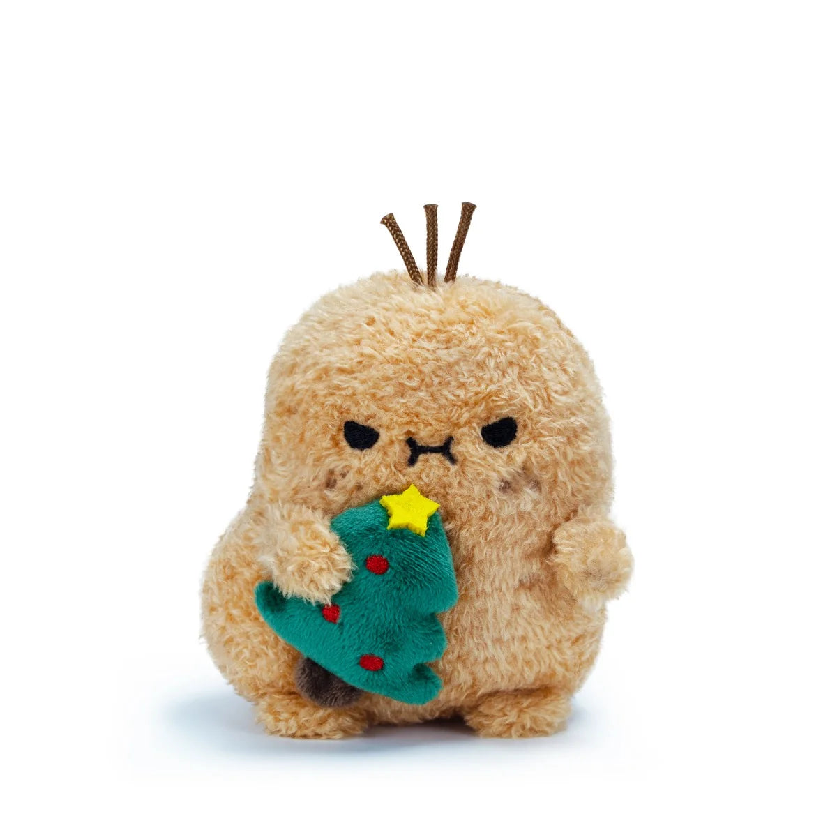 The Noodoll Ricespud Lil’ Rascal is a small, fluffy, beige plush toy with a grumpy face and two brown strands on top of its head. It holds a green felt miniature Christmas tree decorated with a yellow star and red dots.