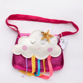 The Children's Cloud Bag is a metallic pink cloud-shaped purse with a smiling white cloud, felt cheeks, closed eyes, a gold star, and colourful ribbon "rain." It features a matching pink strap and a small attached tag.