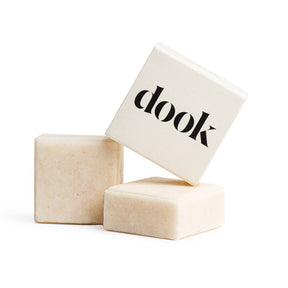 Three beige soap bars are stacked on a white background. The top bar, in a white box labeled "dook," is the Haircare - Solid Shampoo Bar - Made in Scotland, ideal for anyone seeking a sustainable, plastic-free haircare solution.