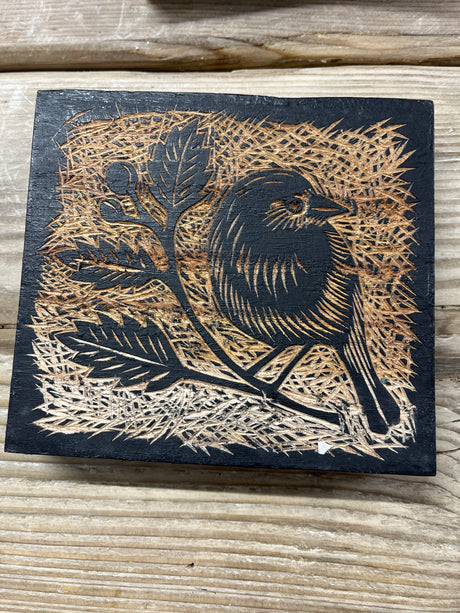 East of India Decorative Wooden Block featuring a natural wood finish and a burnt-wood relief carving of a bird perched on a leafy branch.