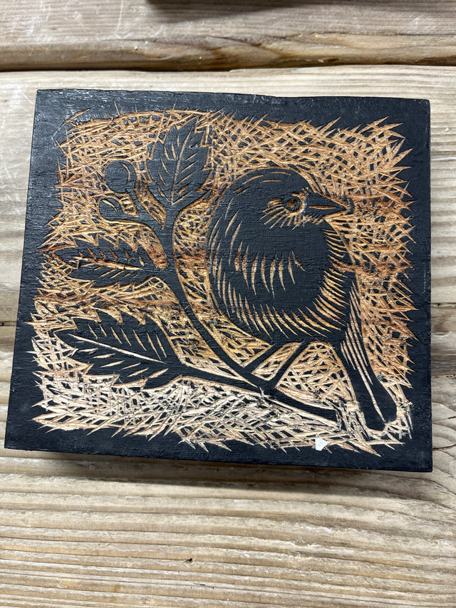East of India Decorative Wooden Block featuring a natural wood finish and a burnt-wood relief carving of a bird perched on a leafy branch.