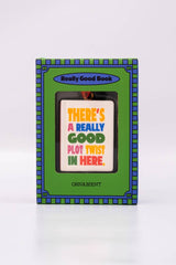 A ban.do Ornament, Book in a green and blue box, featuring the text “There’s a really good plot twist in here.”