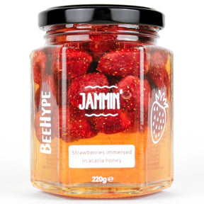 BeeHype Jammin Strawberries In Acacia Honey comes in a clear 220g glass jar with a black lid. The label reads: "Strawberries immersed in acacia honey." Scottish strawberry preserve sweetened only with raw acacia honey—no refined sugar.