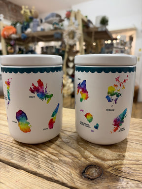 The Scottish Islands Ceramic Jars set features two white ceramic canisters for tea and coffee, each decorated with vibrant watercolor-style maps and island names, perfect for adding charm to any kitchen or shop display.