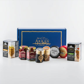 Explore a delightful array of Arran cheddars and gourmet foods from the Isle of Arran Cheese Shop. This exquisite collection includes a variety of cheeses, jars of chutney, and boxes of oatcakes, all elegantly showcased in front of our signature branded gift box—a perfect indulgence for any Cheese Lover Hamper enthusiast.