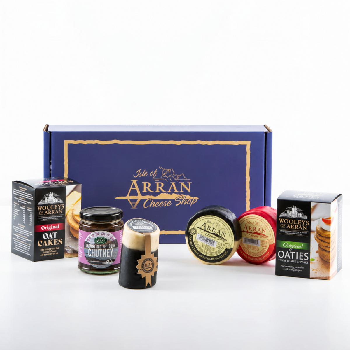 A Simply Arran Hamper containing a box of oatcakes, a jar of red onion chutney, a block of Arran cheese, two round cheeses, and a box of oaty biscuits.