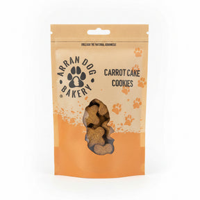 A brown and orange resealable pouch labeled "Carrot Cake Arran Dog Biscuits" displays bone-shaped natural dog treats through a clear window at the bottom, with paw prints decorating the packaging.