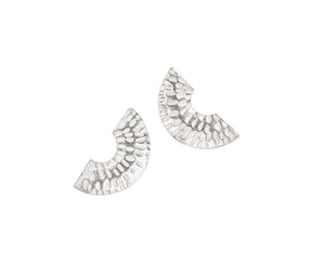 The Caitlin Hegney Gibbous Mini Silver Studs are fan-shaped earrings with a hammered texture and small cutout, handmade in silver—unique jewellery perfect for any occasion, shown on a white background.