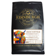 A 200g black bag of Biscoffee from the Edinburgh Tea & Coffee Company, adorned with a colorful cow illustration. The label describes this biscuit coffee as ground coffee with buttery, spicy notes and hints of biscuit. Best before: 13/03/2027.