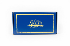 A Classic Arran Gift Box: A blue rectangular cheese gift box with a gold border, featuring "Isle of Arran Cheese Shop" in gold and a small outline of the Isle of Arran above the text.
