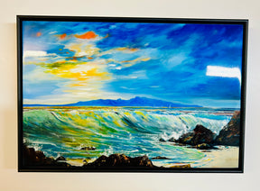 Wild Crossing Ceramic Tile features an ocean wave crashing onto rocks beneath a vibrant sky with sunlight on the water and distant mountains, evoking Arran landscapes in a style reminiscent of Charles Herbert.