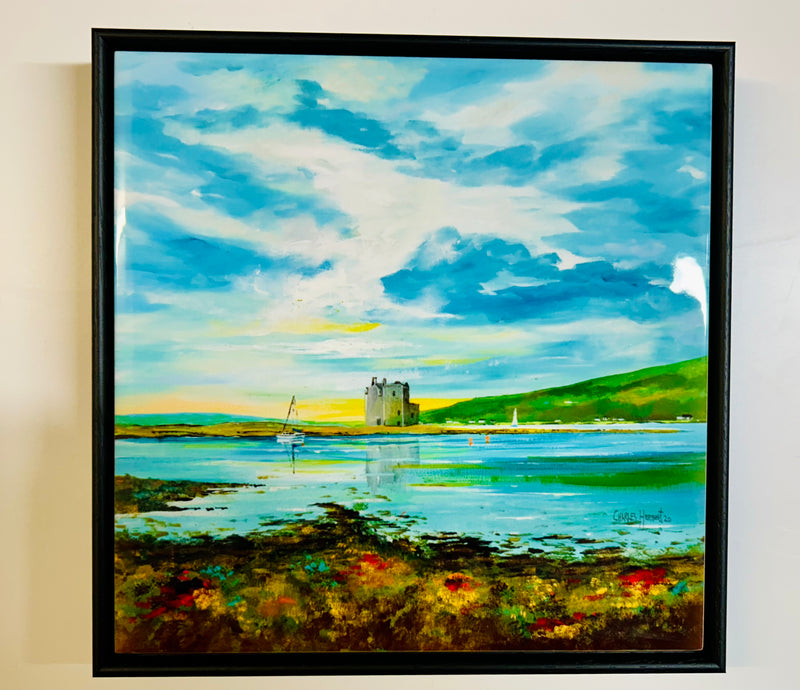 Lochranza Castle Ceramic Tile featuring a coastal scene inspired by Arran, with an island castle, sailboats on blue water, green hills, and a vibrant foreground of grass and flowers beneath a bright sky.