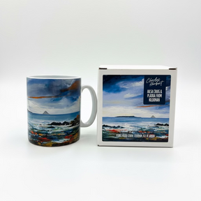 The Ailsa Craig and Pladda Mug and its matching box display Charles Jamieson's coastal painting, “Ailsa Craig & Pladda from Kildonan,” featuring sea, rocks, and distant mountains.