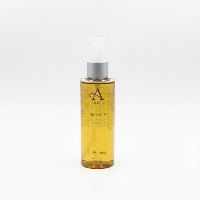 A clear plastic spray bottle containing yellow liquid, labeled “After the Rain Body Mist 100ml – ARRAN Sense of Scotland,” is shown standing upright on a white background.