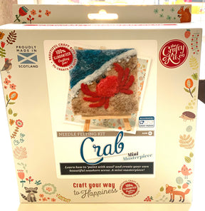 A box for the Crafty Kit Mini Masterpiece needle felting kit featuring felted crab art on an easel. The text says "Crab Mini Masterpiece," with animal and ocean designs on the border. Made in Scotland.