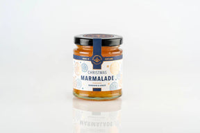A small glass jar of Christmas Marmalade with a festive label featuring snowflake illustrations, perfect as a holiday spread.