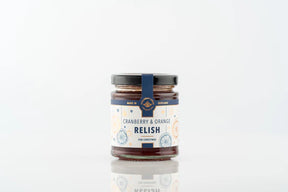 A jar of Christmas Cranberry & Orange Relish with a white label featuring orange slice illustrations and blue text.