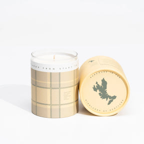 Two beige tartan-patterned Isle of Skye Hebridean Breeze Large Candle containers; one upright with visible wick, the other on its side revealing a green map and “Handmade on the Isle of Skye—Hebridean Breeze.”.