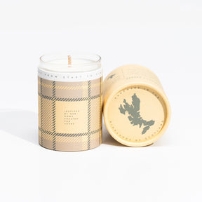 The Isle of Skye Hebridean Breeze Miniature Candle comes in a plaid-patterned container with a matching cylindrical lid, featuring a silhouette of Scotland and the phrase "Handmade in the Highlands of Scotland.