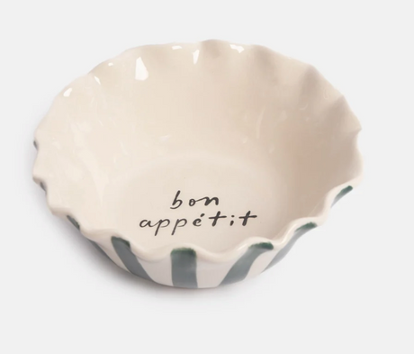 Caroline Gardner Teal Stripe Bon Appétit Scalloped Bowl, an off-white glazed stoneware bowl with a scalloped edge, teal exterior stripes, and the words “bon appétit” printed in black on the inside.