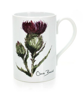 The Clare Baird Porcelain Mug showcases a hand-drawn illustration of a purple thistle with green leaves and stems, finished with “Clare Baird” signed beneath the artwork. This charming Scottish mug beautifully captures Clare Baird’s signature style.