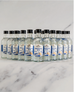 A selection of Eden Mill Original Gin Miniature 5cl bottles arranged in three rows on a light marble surface with a marble background.