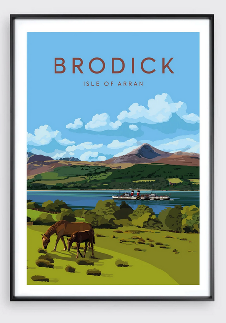 Framed poster titled "Catriona Tod Brodick Bay Portrait" depicting two horses grazing on a green field, a ferry on the bay, and mountains beneath a blue sky with clouds at Brodick, Isle of Arran.