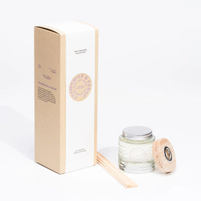The Chamomile and Cedar Reed Diffuser from Isle of Skye Candle Company includes a glass jar, wooden reeds, and ring in a tall beige box—perfectly arranged for an elegant display.