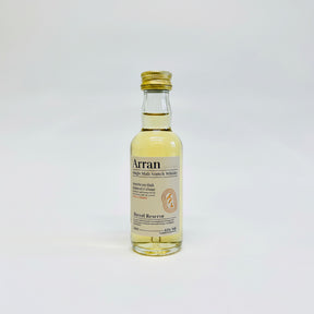 The Arran Barrel Reserve Single Malt Whisky Miniature 5cl showcases a golden cap, with its transparent glass revealing a pale amber liquid that is sure to entice any whisky lover. The label prominently features the terms "American Oak" and "Natural Colour," and it has an alcohol content of 43%.