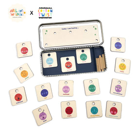 The Feelings Chart for Children includes wooden emotion cards and tokens labeled "scared," "calm," and "happy." Stored in a metal tin with a mood tracker, it's ideal for building emotional intelligence and serving as a feelings chart.