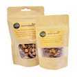 Two brown resealable bags labeled “Sweet & Spicy Roasted Nuts: 70g” display a tempting nut mix through clear windows. The eco-friendly snack bags feature ingredient details and each one is marked with a “Great Taste” award sticker.