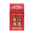 A Red Velvet Gourmet Popcorn Snack Box featuring a vibrant red design and a window that reveals the delicious popcorn inside. The packaging highlights gluten-free, all-natural ingredients, and a unique combination of cream cheese frosting with decadent white chocolate flavor. This irresistible snack is the perfect treat for anyone who enjoys distinctive caramel popcorn creations.