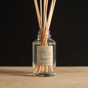 The Hebridean Breeze Diffuser from Skye Candle Company, inspired by Scottish islands and sea kelp, sits on a wooden surface with natural reeds against a dark background.