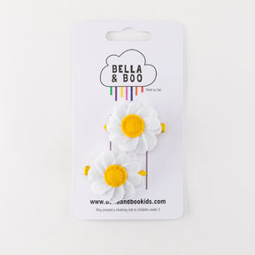 Daisies Hair Clips: Two white felt daisy hair clips with yellow centers on alligator clips, attached to a Bella & Boo branded card with a cloud design and colorful text—an ideal Spring gift.