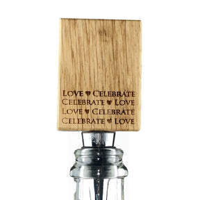 The Oak Bottle Stopper - Love features “LOVE ♥ CELEBRATE” and “CELEBRATE ♥ LOVE” engravings on wood, displayed atop a glass bottle—an ideal anniversary or wedding gift.
