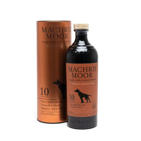 A bottle of Machrie Moor 10 Year Old Arran Whisky with a matching copper-colored cylindrical case, both featuring black text and a black dog illustration on the label.