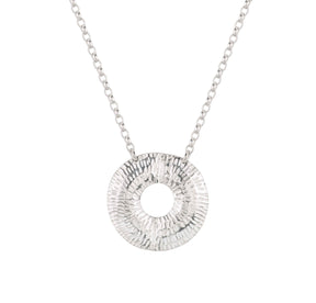 The Caitlin Hegney Torus Small Silver Necklace features a handcrafted hammered circular pendant with an open center, elegantly suspended from a delicate silver chain.